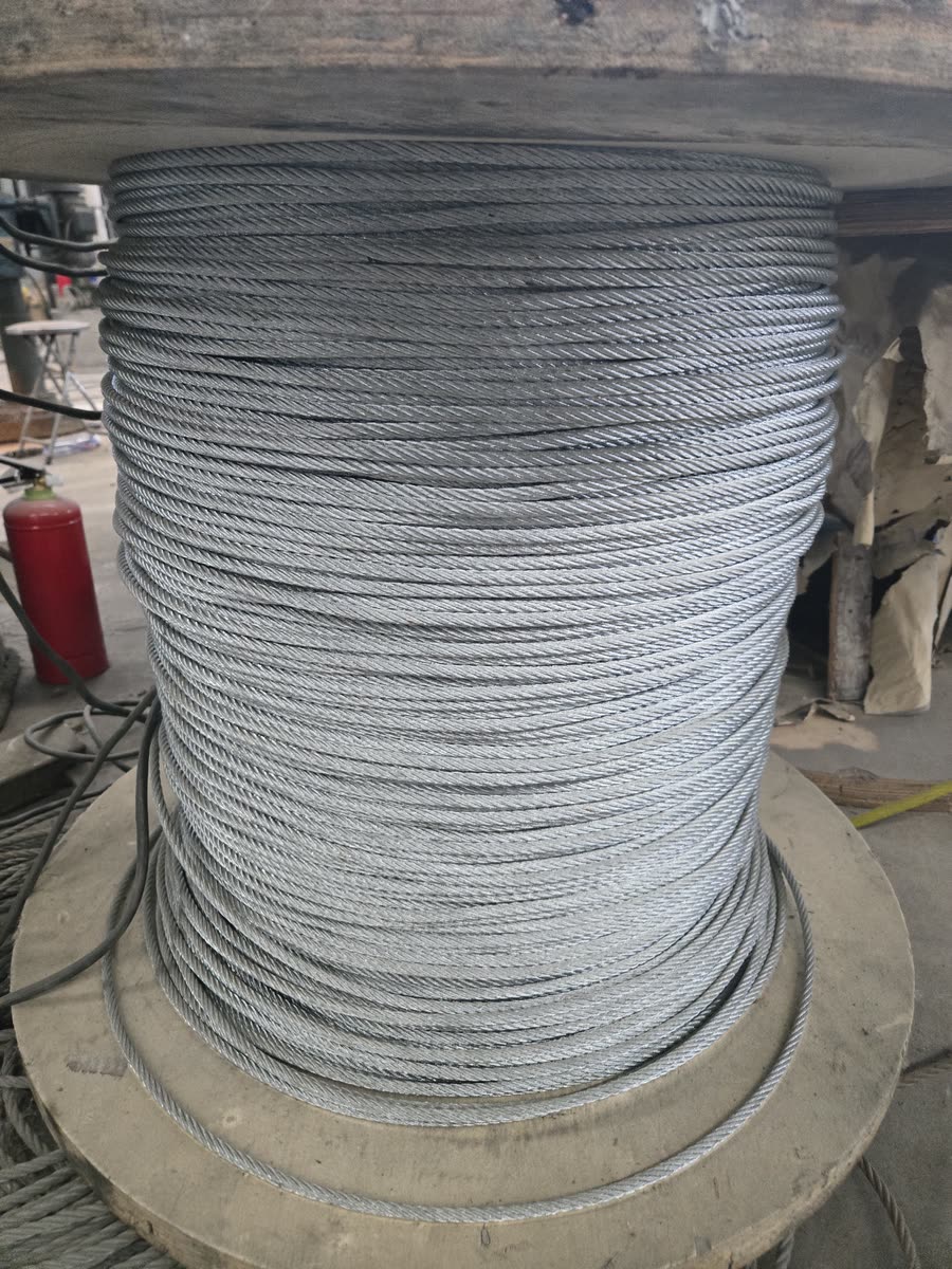 Galvanised steel load cable coiled on a wooden reel
